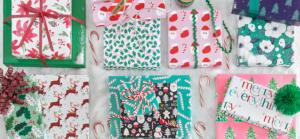 A collection of Charleston Wrap Christmas wrapping paper and gift bags, showcasing festive designs and vibrant colors.