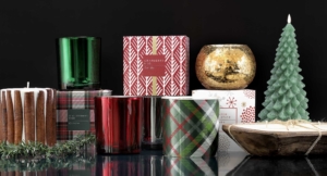 A festive arrangement of Christmas candles and gift boxes displayed on a sleek black surface, creating a warm holiday ambiance.