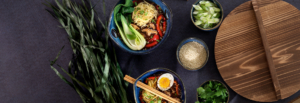 A table set with various bowls of food accompanied by chopsticks, inviting a communal dining experience.