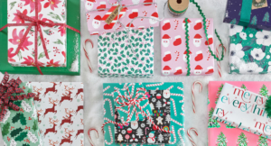 A collection of Charleston Wrap Christmas wrapping paper and gift bags, showcasing festive designs and vibrant colors.