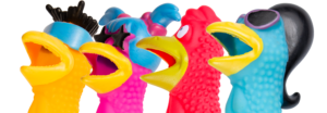 A collection of vibrant plastic rubber chickens - only their heads are visible arranged together in a playful display.