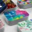 A collection of uniquely designed personalized lunch boxes, perfect for a fall school fundraising event.